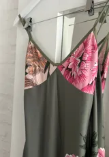 Vestido largo de tirantes finos, color verde con estampado floral en tonos rosados y beige.