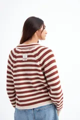 Cardigan tejido de punto a rayas horizontales color marrón y crudo, con cuello polo y cierre frontal con botones.