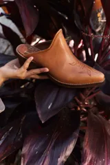 Mules de cuero color marrón claro con punta fina y diseño bordado estilo western. Tacón bajo de madera.