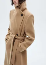 Abrigo largo color camel con cuello chimenea, cierre cruzado con botones y lazo ajustable en la cintura.