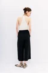 Pantalón crop negro de corte amplio, con cintura elástica ajustable con cordón y bolsillos laterales.