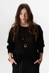 Sweater beige de tejido fino y mangas largas.