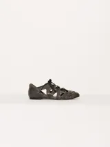 Zapato bajo acordonado de cuero texturado color negro, con diseño calado y aplique metálico con el logo de la marca.