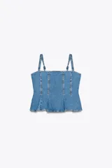 Top de denim azul con escote recto, tirantes finos ajustables y bajo evasé. Cierre trasero con cremallera.