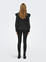 Camisa de jean negro con cuello clásico, mangas largas y volantes con terminación desflecada en el frente y hombros.