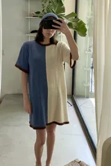 Vestido tejido a rayas horizontales en tonos beige y marrón, con cuello redondo y mangas cortas con ribete negro.