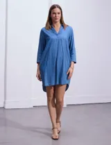 Vestido corto de tencel color azul denim, con cuello solapa, escote en V y mangas 3/4 regulables con presilla y botón.