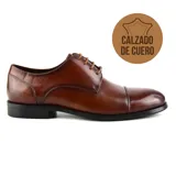 Zapato de vestir acordonado de cuero negro, con puntera lisa y suela de goma.