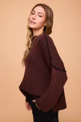 Buzo color crema tejido en algodón, de silueta holgada, mangas anchas y cuello bote.