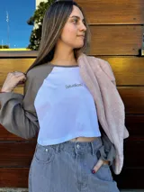 Remera corta blanca con mangas largas azul marino y logo "[studios]" estampado en rojo.