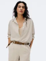 Camisa de lino color beige, con corte holgado y botones frontales.