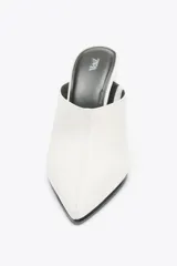 Zapato de mujer tipo mule, color blanco, con punta fina y tacón de cuña.