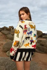 Sweater de lana tejido a mano color crudo, con cuello redondo y puños negros. Presenta bordados de figuras abstractas en colores rojo, azul, amarillo, verde y naranja.