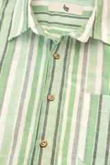 Camisa de manga corta con rayas verticales en tonos verde, blanco y gris. Tiene cuello clásico, bolsillo en el pecho y botones de coco.