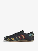 Zapatillas Adidas modelo Tokyo, color negro con bordados florales multicolores. Diseño de corte bajo con las tres tiras laterales y suela de goma color caramelo.