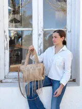 Cartera de cuero color beige con flecos, doble asa corta y correa larga desmontable.