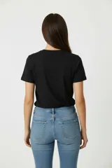 Remera negra de algodón con estampado de mariposa y frase "Set Yourself Free" en color celeste.