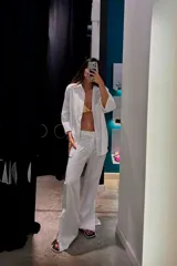 Pantalón de vestir a rayas verticales celestes y blancas, de corte recto y tiro alto.