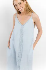 Vestido largo de lino color blanco, con breteles finos y detalle de costura o aplique vertical en el centro del frente.