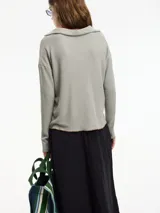 Sweater de punto blanco con cuello tipo polo y manga larga. Pespunte a contratono en la terminación.