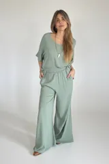 Conjunto verde claro compuesto por un pantalón palazzo de lino con cintura elastizada y un remerón de mangas cortas con escote redondo. Incluye collar dorado con dije blanco.