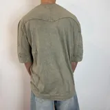 Remera gris con efecto lavado, corte oversize y mangas 3/4.