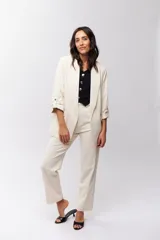 Blazer color crema con solapas, corte recto y mangas 3/4 con detalle de botón.
