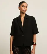 Blazer negro de viscosa con mangas cortas, solapas en el cuello y botón metalizado.
