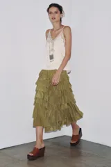 Falda midi color verde oliva confeccionada en tejido con viscosa. Presenta cintura elástica y detalle de volantes en el mismo tejido.