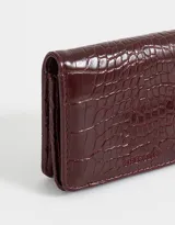 Billetera negra de cuerina con textura efecto croco y correa lateral.