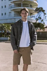 Camisa de denim negra de manga larga con cuello clásico y cierre con botones. Diseño amplio con bolsillos en el pecho.