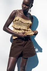 Shorts de jean blancos, tiro medio, corte mom fit, con cinco bolsillos y cierre frontal con cremallera y botón.