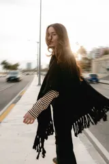 Ruana tejida en lana merino color amarillo pastel, con terminación de flecos.