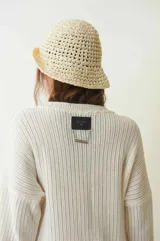 Sweater tejido color crudo, de manga larga con efecto desgastado y deshilachado en el ruedo y puños. Tiene cuello redondo y calce holgado.