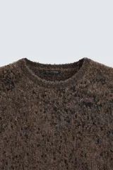 Jersey marrón con diseño jacquard pixelado en negro, de corte relaxed, cuello redondo y manga larga con terminaciones en rib.