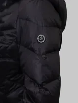 Campera acolchada negra de nailon con relleno de plumón (90% plumón, 10% plumas), cierre frontal con cremallera, bolsillos laterales, cuello alto con capucha y diseño plegable.