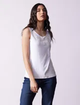 Blusa blanca sin mangas de seda fría, con cuello redondo y apliques de flores blancas.
