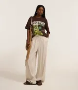 Pantalón femenino de corte fluido, color beige claro, con cintura elástica ajustable mediante un lazo.