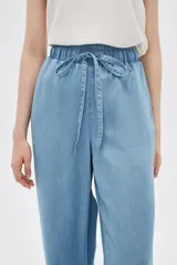 Pantalón de jean celeste, de corte ancho, con cintura elástica y cordón ajustable.