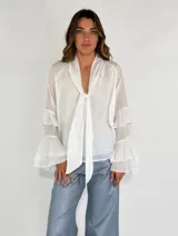 Camisa color beige de mangas largas con volados.