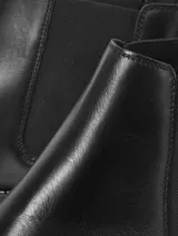Botas Chelsea negras de cuero, con elásticos laterales y suela de goma.