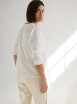 Remera blanca de algodón con corte holgado y costuras a la vista en color beige.