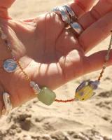 Collar corto de cuentas de colores con dije de pez de cerámica, piedras naturales y detalles en plata 925.