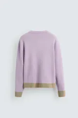 Cárdigan lila con diseño floral, cuello redondo, manga larga, rib en puños y ruedo, y cierre frontal con botones.