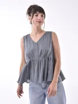 Blusa gris sin mangas con escote en V y botones frontales.