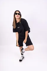 Remera blanca de corte holgado con logo pequeño bordado en negro en el pecho.
