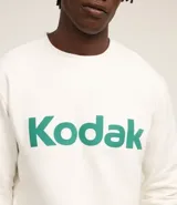 Buzo blanco de algodón y poliéster con cuello redondo y mangas largas. Estampa frontal con la palabra "Kodak" en color verde.