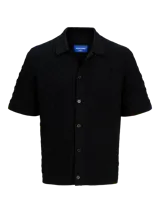 Polo negro de tejido cable knit con fit relajado, cuello tipo polo, manga corta y cierre con botones.
