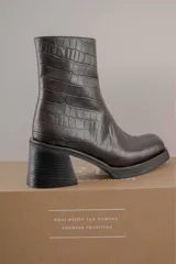 Bota de cuero color marrón con caña media y punta cuadrada.