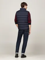 Chaleco acolchado Tommy Hilfiger color azul marino, con cuello alto, cierre de cremallera y dos bolsillos laterales.